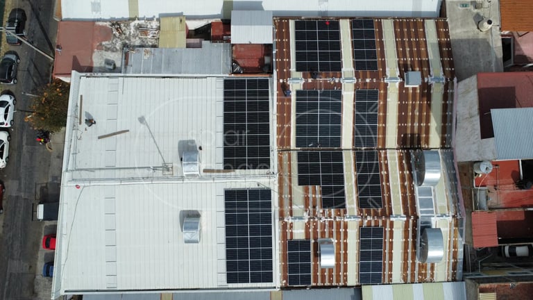 Aerial view of rooftops with solar panels and mixed architectural styles in urban setting